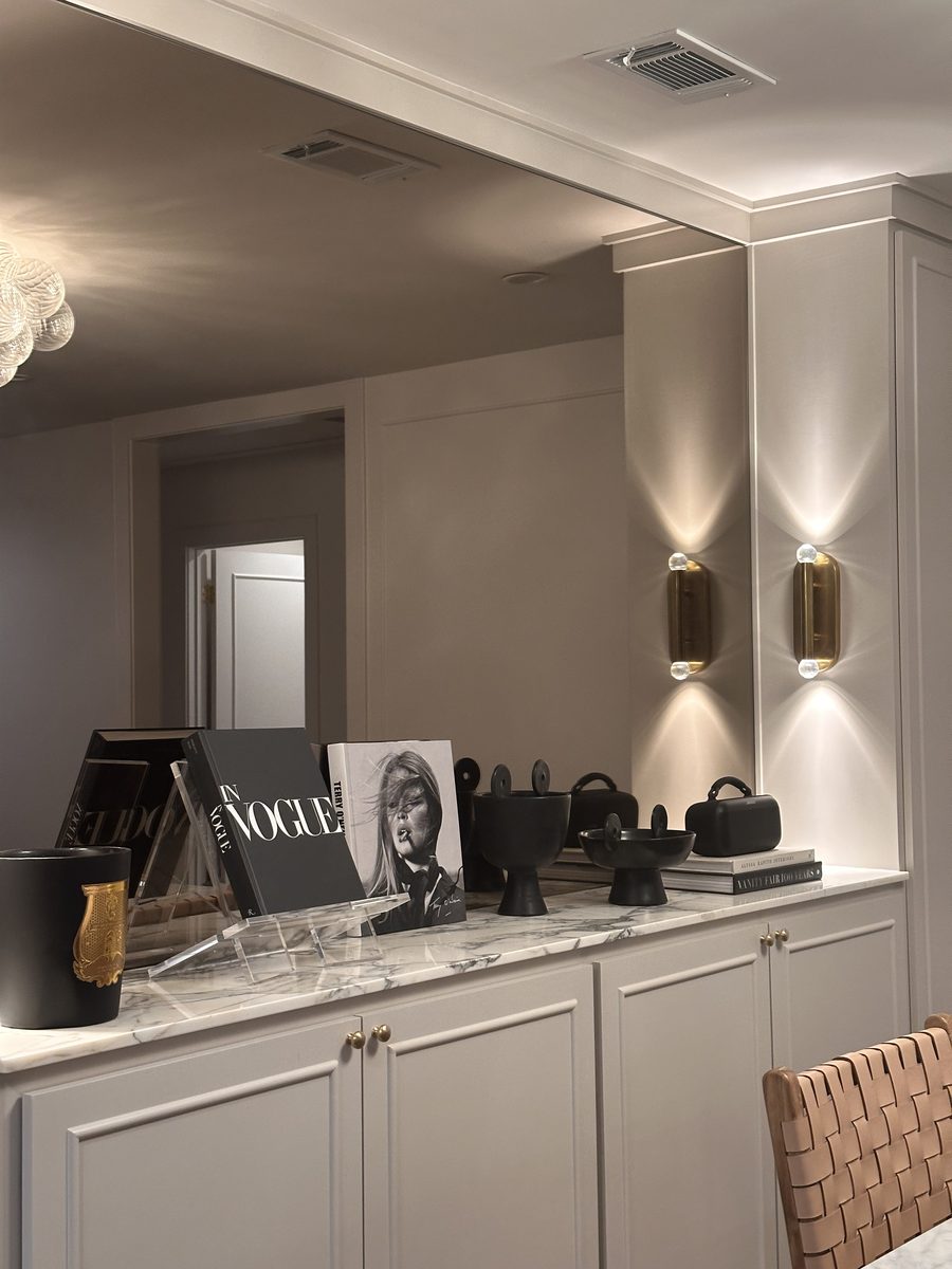 Dining console with Vogue book on stand and gold sconces